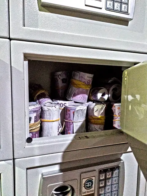 Coffre-fort ouvert, rempli de rouleaux de billets