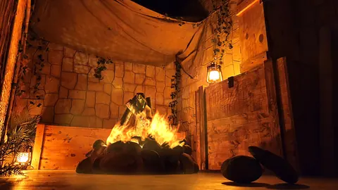 Archaeologists’ camp at the foot of the temple: campfire, stretched canvas and lantern