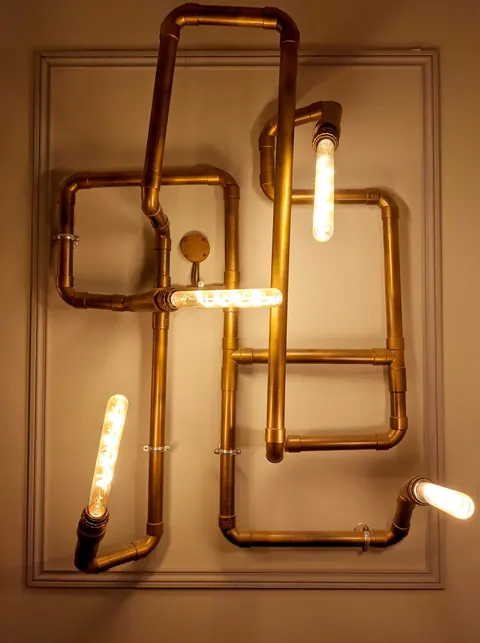 Luminaire en tuyaux de cuivre dans le salon du manoir