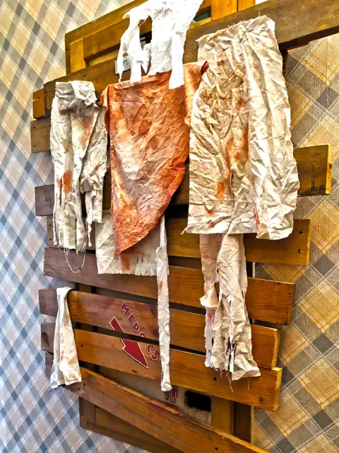 Blood-stained clothes hanging on pallets